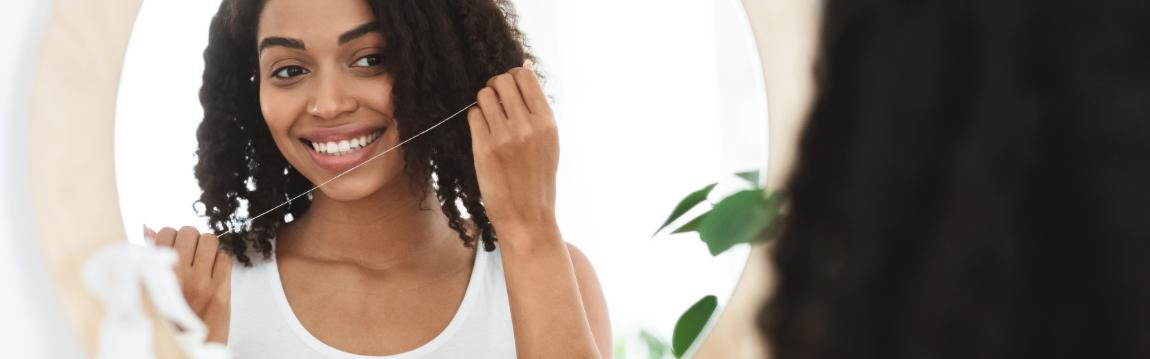 Girl using dental floss at home